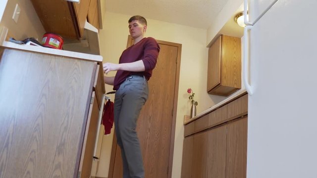 Person taking food out of the cupboard. Slow zoom in. Shallow depth of field. 24 fps. 1080p.
