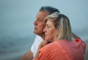 Obraz premium A double profile portrait of a middle-aged couple, looking afar, in front of the blue sky
