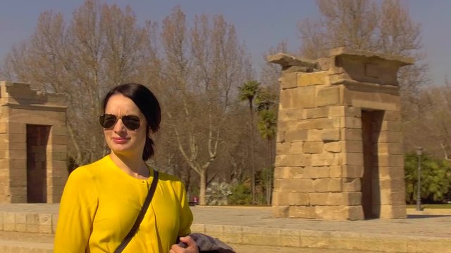 Young female tourist walking past the Egyptian monument, Temple of Debod, in Madrid