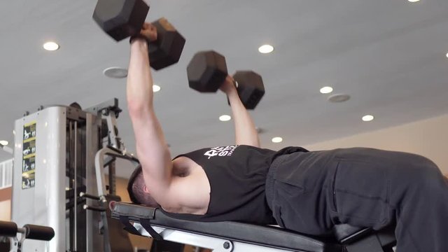 Person lifting weights and exercising in the gym. 24 fps. Shot in 4k exported in 1080p. Shallow depth of field.