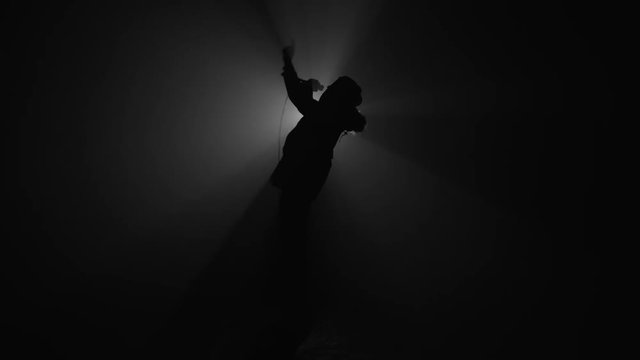 Silhouette of rapper performing with microphone