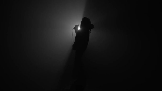 Silhouette of rapper performing with microphone