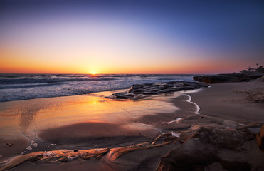 Sun hits the horizon at San Diego's Windansea Beach on a calm Spring evening