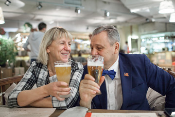 An elderly couple enjoying their beer in a cafe
