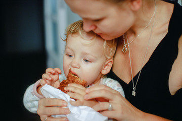 A mother feeds her baby with a croissant