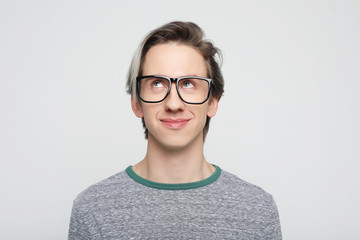 young man with emotions on his face a grey background