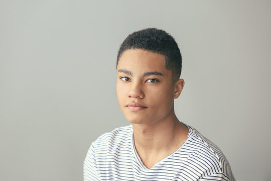 Sad African-American Teenage Boy On Grey Background