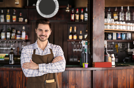 Young male waiter in restaurant
