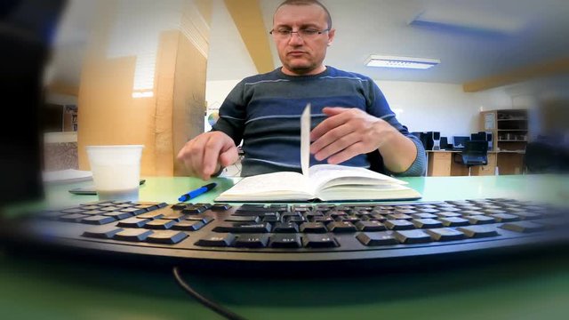 Surveillance hacking view from computer web camera to IT programmer working on computer in an office