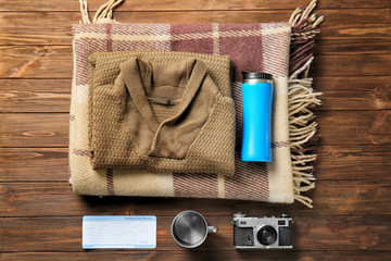Set of items for tourist on wooden background