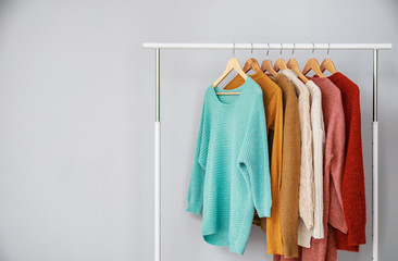 Rack with stylish clothes on grey background