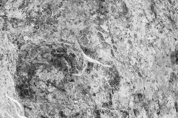 Vintage monochrome background. Rough painted wall of black and white color. Imperfect plane of grayscale. Uneven old decorative backdrop. Texture of black-white. Monochromatic ornamental stony surface