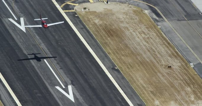 Airplane flies over parking lot, aerial