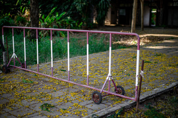 Fototapeta premium The background of the steel fence is red in color and has a small rubber wheel, can easily be used to block the car in-out area in the garden.