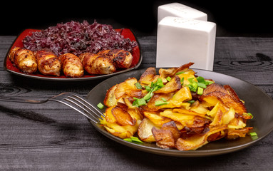Fried homemade grilled sausages or chevapchichi with stewed sauerkraut on a wooden rustic background
