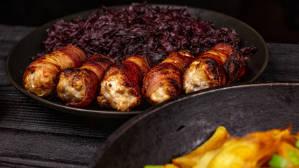 Fried homemade grilled sausages or chevapchichi with stewed sauerkraut on a wooden rustic background