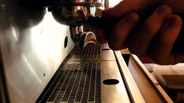 Close up view of chrome espresso machine pouring steaming hot double shot coffee into glass cups.