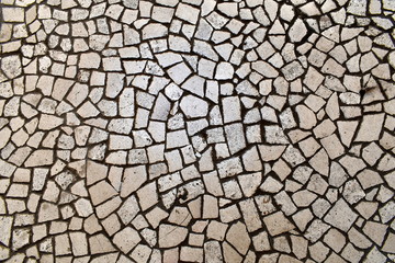 Irregular white stones rough mosaic pattern. Broken tiles, floor, pavement.