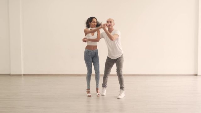 Caucasian Couple Partners in Light Colored Jeans Pants White Shirts anh Shoes Practicing Moves in Bright Dance Studio