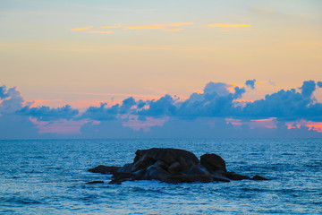 Fototapeta premium Rock in the sea waves at sunset beautiful, sea wave impact the stone on beach in the sunset time