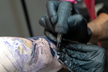 Tattoo master makes a client a colorful tattoo