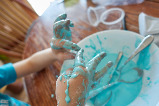 Young Child With Focus On Slime Covered Hands  