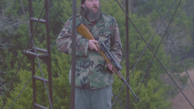 Mercenary smoking at guard post, spotting enemy and loading rifle