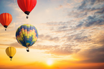 Colorful balloons floating in the sky at sunset.