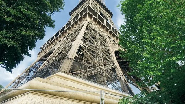 Eiffel Tower timelapse hyperlapse in a sunny summer day. Paris, France. Green trees and cloudy sky