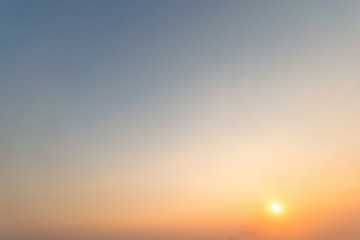 Sky blue and orange light of the sun through the clouds in the sky