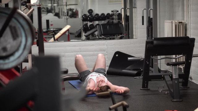 Young bearded male training abs hard in an old, rusty Arnold era gym (Gold's Gym)