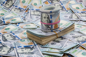 Background from dollars. Notes of one hundred American dollars are scattered across the background.