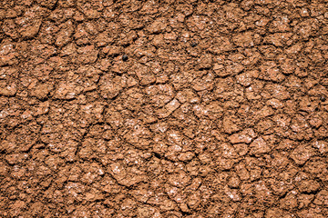 Dry earth, cracked ground, and arid weather.  Dry skin care for parched texture.  Background closeup.