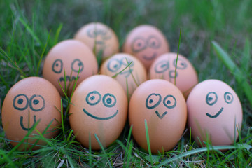 Nine easter eggs with different facial expressions on painted faces laying together as team in...