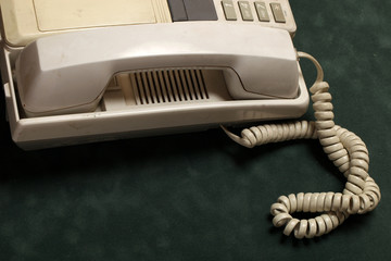 vintage phone with handset and answering machine on green velvet,the handset lies next