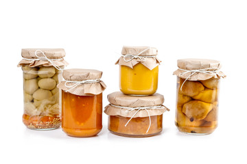 Pickled vegetables and colorful jams in glass jars