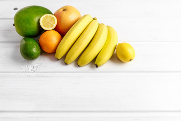 Various fruits on white wooden background.