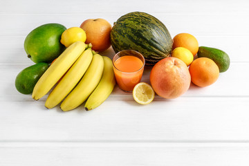 Various fruits on white wooden background.