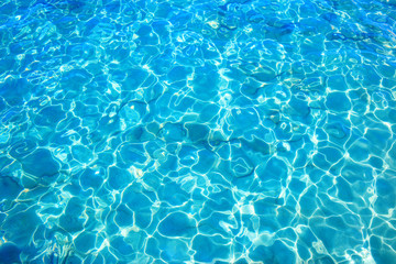 Blue clear water with rippled surface and sand bottom.