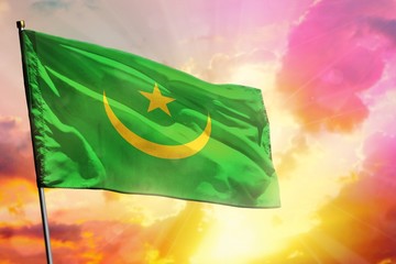 Fluttering Mauritania flag on beautiful colorful sunset or sunrise background. Success concept.