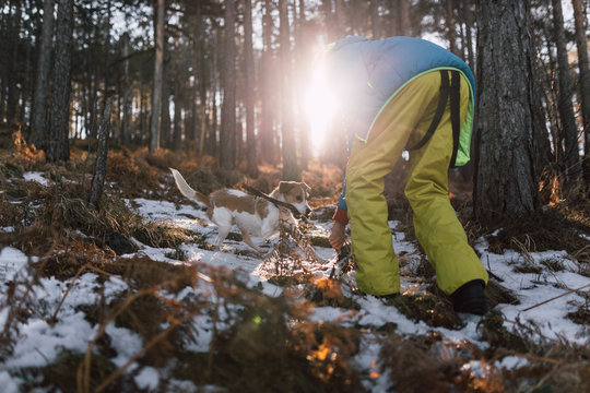 Young teenager playing with a dog outside in the woods