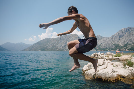 Young man jumping in to water