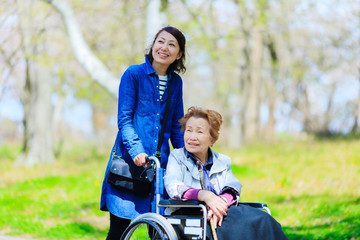 車椅子の高齢女性と介護をする女性