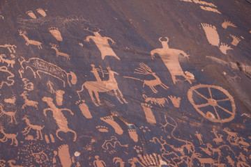 Ancient petroglyphs carved into a sandstone wall in the desert in the American southwest.