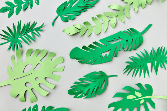 Tropical green leaves handmade pattern from colored paper on a g