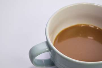 Close up hot cappuccino coffee in a blue cup isolated on a white background