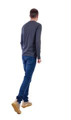 Naklejka premium Back view of going handsome man .