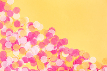 Orange, pink and white confetti on orange background. Flat lay style. Top view. Copyspace for text.