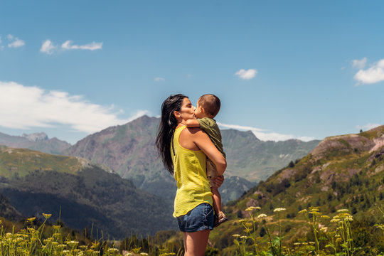 Woman holding her son and looking to moutain views