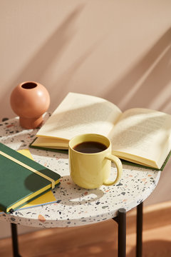 Composition of mug, book and notebook on table.